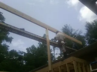 Carpenter setting a ridge beam over a new addition frame — Ice Dam Removal by Roofing Brothers in Hagaman