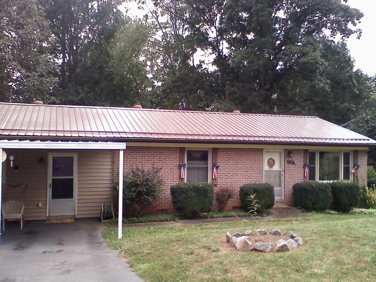 Bronze metal roof and carport on a brick ranch home — Roof Repair work by our crew in Hagaman